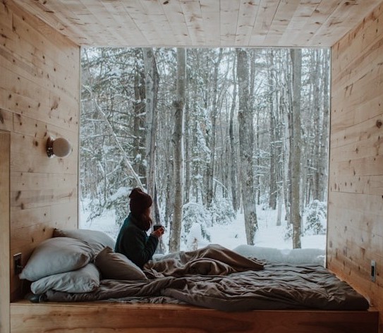 A person sitting inside a cabin by a window
