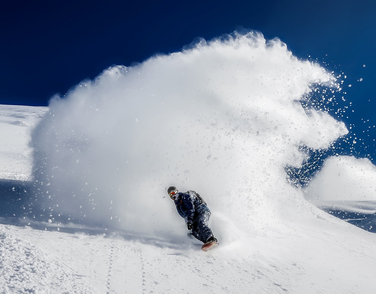 Snowboarder with snow behind