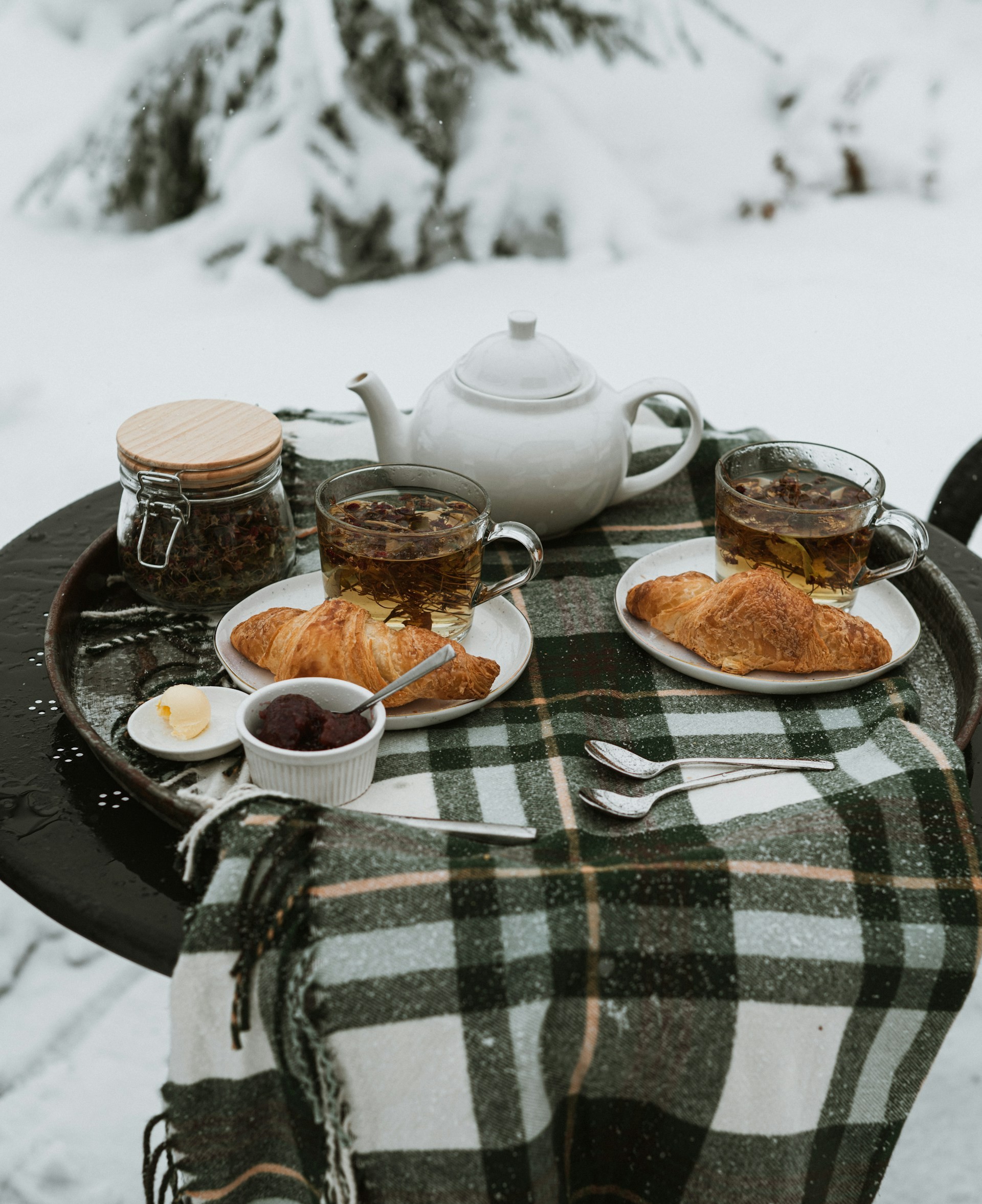 A table with tea and food in snow